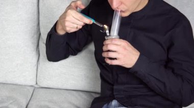 İçerde marihuana içen genç adam. Esrar alternatif tıp ve şifalı bitkiler konseptidir.