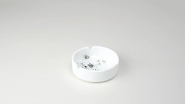 Dişiler beyaz arka planda kül tablasında sigara söndürdüler. Sigarayı bırakma, kötü alışkanlıklar ve sağlığa zarar verme kavramları.