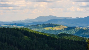 Beyaz bulutlu mavi gökyüzü ile inanılmaz dağ manzarası, Ukrayna, Karpatlar 'da güneşli bir yaz günü. Doğal dış seyahat geçmişi.