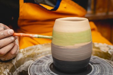 Potter çömlekçi çarkı üzerinde çalışıyor. Çömlek atölyesinde seramik sofra takımı yapma süreci. El işi ve sanat konsepti.