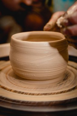 Potter çömlekçi çarkı üzerinde çalışıyor. Çömlek atölyesinde seramik sofra takımı yapma süreci. El işi ve sanat konsepti.