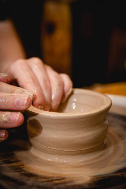 Potter çömlekçi çarkı üzerinde çalışıyor. Çömlek atölyesinde seramik sofra takımı yapma süreci. El işi ve sanat konsepti.