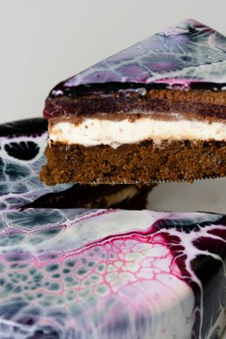 Siyah, kırmızı ve beyaz aynalı kaplama kremalı pasta. Fransız tatlısı. Pastanın üzerindeki dondurulmuş ayna kreması. Pişirme ve şekerleme konsepti.