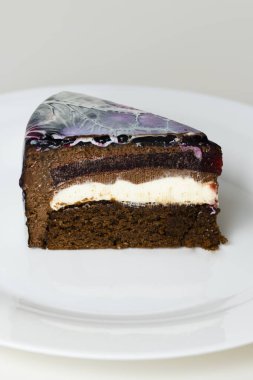 Siyah, kırmızı ve beyaz aynalı kaplama kremalı pasta. Fransız tatlısı. Pastanın üzerindeki dondurulmuş ayna kreması. Pişirme ve şekerleme konsepti.