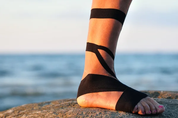Нога с черной лентой физиотерапии — стоковое фото
