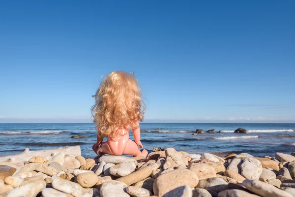 Κούκλα μωρό κάθεται στην ακτή Royalty Free Φωτογραφίες Αρχείου