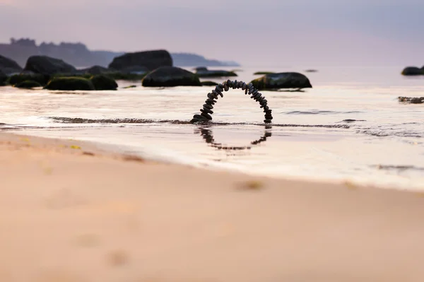 Arch of pebbles on the beach — Stock Photo, Image