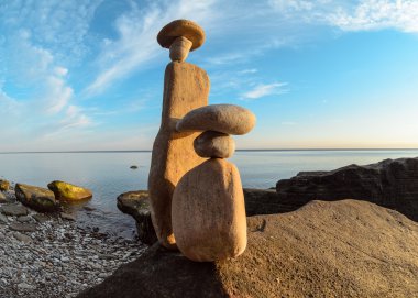 Symbolic figurines on seashore clipart