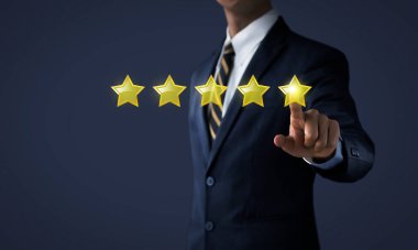 Derecelendirme, sıralama, gözden geçirme, değerlendirme veya sınıflandırma kavramını yükselt. İşadamı, koyu tondaki arka planda beş yıldızın yerini alıyor..