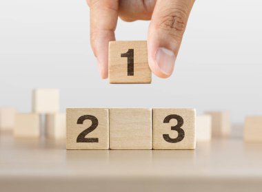 Beyaz arka planda bir podyum olarak dizilmiş tahta blokları elle düzenlemek. Başarı, galibiyet, zafer ya da en üst düzey konsept.