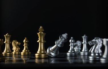 Satranç (King oyunu kazanır) siyah arka planda. Başarı, iş stratejisi, zafer, galibiyet, şah mat, entelektüel, taktik, yenilgi, vuruş, hücum, saldırı, lider ya da liderlik konsepti.