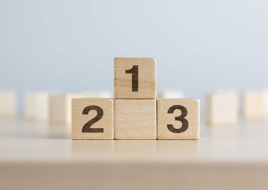 Tahta bloklar beyaz arka planda bir podyum gibi istifleniyor. Başarı, galibiyet, zafer ya da en üst düzey konsept.