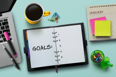 New Year goals, resolution or action plan concept. Notebook on table with laptop, calendar, coffee, plant and stationery. Flat lay (top view) notepad for input copy or text on turquoise background. clipart