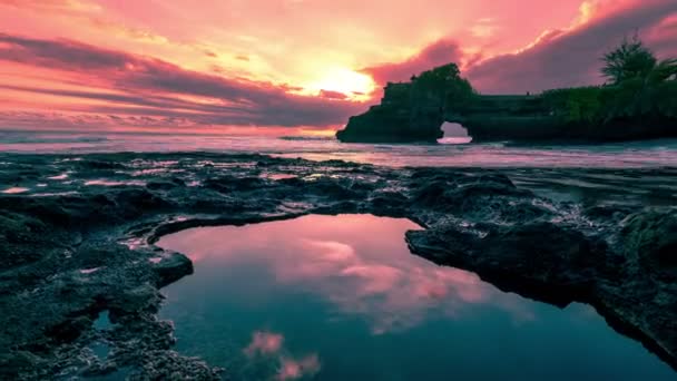 Puesta de sol en la playa del mar hecha de rocas con agujeros llenos de agua de mar en el templo de Batu Bolong. 4K Timelapse - Bali, Indonesia, junio de 2016 . — Vídeo de stock