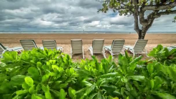 Meer und Strand mit Liegestühlen in Großaufnahme bei bewölktem Wetter. 4k Zeitraffer - bali, Indonesien, Juni 2016. — Stockvideo
