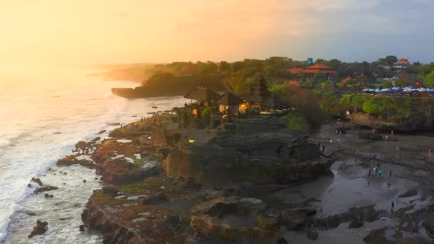 Pura Tanah Lot chrám na pláži při západu slunce v přímořském ostrově Bali, Indonésie. Silueta chrámu. Letecký pohled 4K — Stock video