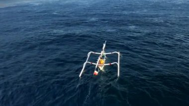 Turkuaz mavi okyanus suyu ve teknedeki balıkçı manzaralı. Hava aracı 4K 'yı vurdu.