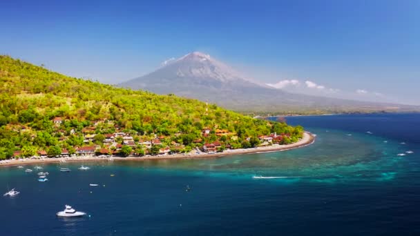 ジェムルーク湾、アメッド、バリ、インドネシアのボートとターコイズブルーの海の水と熱帯の山々の風景. — ストック動画