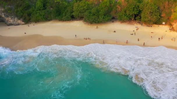 巨大な波がインドネシアのバリ、ヌサペニダのケリングビーチで人々と砂浜を襲いました。空中ビュー｜4K — ストック動画