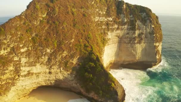 Hatalmas hullámok elérték a homokos tengerparton és sziklák Kelingking Beach, Nusa Penida, Bali, Indonézia. Légi felvétel 4K — Stock videók