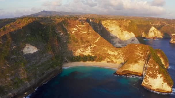 从空中俯瞰印度尼西亚开林金海滩的悬崖、蓝浪和黄金海岸。靠近巴厘岛的旅游天堂目的地景观。大浪的Idyllic沙地. — 图库视频影像