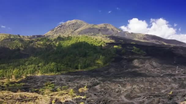 Пейзаж влажного тропического леса и черного поля лавы вокруг величественного вулкана Батур в Бали, Индонезия. Вид с воздуха 4K — стоковое видео