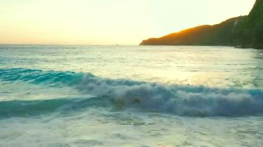 Nusa Penida Adası, Bali, Endonezya 'daki Kelingking Plajı. İnanılmaz bir vahşi doğa manzaralı kumlu plajda, kayalık dağları ve gün batımında temiz Hint okyanusu suyuyla masmavi bir lagünü olan bir kız..