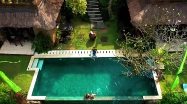 Mutlu aile Ubud, Bali, Endonezya 'daki tropik bir cennette lüks bir sonsuz havuzda yüzer ve dinlenir. Anhera Süit Spa, Ubud, Bali, Endonezya - 15 Temmuz 2019.