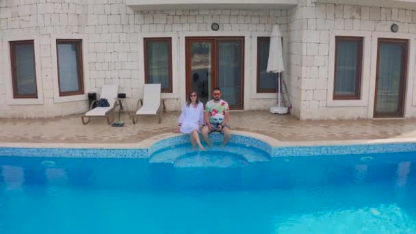 Giovane coppia di moda amore vicino alla piscina presso la villa di lusso in vacanza a Kas, Fethiye, Turchia. Vista aerea 4K. — Video Stock