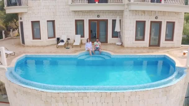 Ζευγάρι χαλαρώνουν κοντά στην πισίνα στο πολυτελές ακίνητο για διακοπές στην Kas, Fethiye, Τουρκία. Αεροφωτογραφία 4K. — Αρχείο Βίντεο