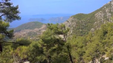 Uçurumda oturan bir çift adam ve kadın dağların keyfini çıkarıyorlar. Aşk ve Seyahat mutlu duygular Yaşam tarzı konsepti. Hava görüntüsü 4K.