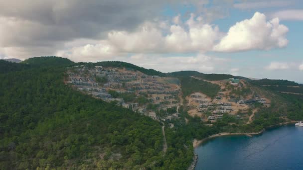 Hotel e moradias em construção em montanhas e vista para o mar na popular cidade turca de Bodrum. Vista aérea 4K. — Vídeo de Stock