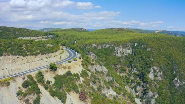 Carros na estrada sinuosa através das montanhas. Vista aérea 4K. — Vídeo de Stock