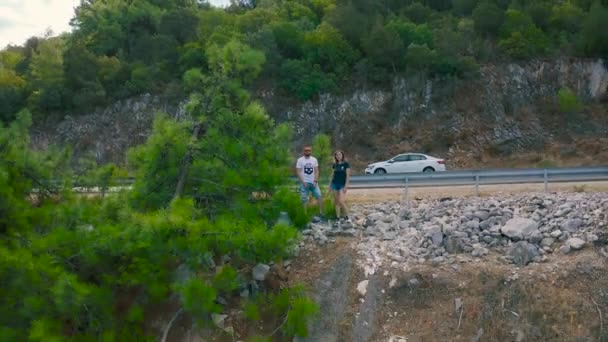 Casal jovem olhando para o mar a partir das montanhas da costa em Bodrum, Turquia. Vista aérea 4K. — Vídeo de Stock