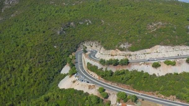 Los coches atraviesan la curva. Aerial top down drone shot above the winding mountain road. — Vídeo de stock