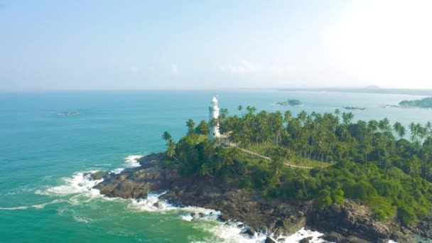 Vue panoramique d'un vieux phare blanc situé sur la côte d'une île tropicale près du Sri Lanka. Vue aérienne 4K. — Video