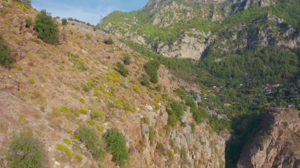 Туристы мужчина и женщина стоят на краю скалы каньона Долины Бабочек в Фетхие, Турция. Концепция путешествия. Вид с воздуха 4K. — стоковое видео