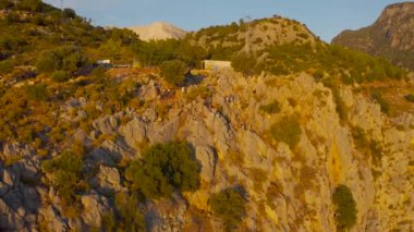 Oludeniz, Fethiye, Türkiye - 20 Mart 2021. Turistler Kelebek Vadisi 'nde bir uçurumda oturuyorlar. En popüler turizm merkezi. Hava görüntüsü 4K.