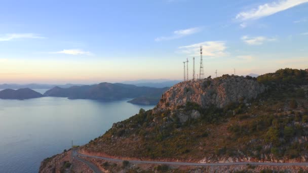 Grupa anten telekomunikacyjnych na szczycie góry i widok na morze. Widok z powietrza 4K. — Wideo stockowe