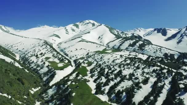 Вид на альпийские горы со снегом и плотиной под высокогорным пастом в Алма-Ате, Казахстан. Вид с воздуха 4K. — стоковое видео