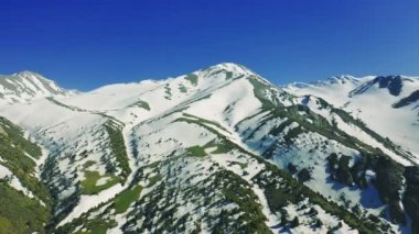 Almaty, Kazakistan 'daki dağ çayırları ve kar zirveleri. Hava görüntüsü 4K.