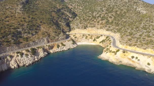 Auto 's rijden langs de asfaltweg langs de Middellandse Zee met azuurblauwe zee en strand in Demre, Antalya, Turkije. Luchtfoto 4K. — Stockvideo