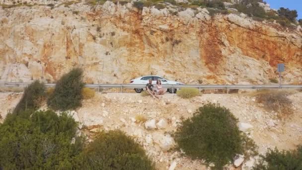 Молодая пара туристов сидят на берегу Средиземного моря по дороге из Демре в Анталию, Турция. Вид с воздуха 4K. — стоковое видео