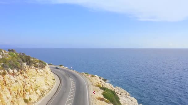 Luchtlandschap van de kustlijn en een weg zeegezicht. Auto 's rijden over de asfaltweg langs de zonnige Middellandse Zeekust van Turkije. Luchtfoto 4K. — Stockvideo