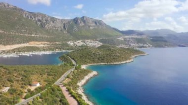 Yol, Türkiye 'nin Antalya kentinde güzel bir koy, büyüleyici bir doğa ve dağlar üzerine kurulmuş Kas yarımadası boyunca uzanır. Hava görüntüsü 4K.