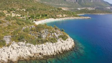 Deniz sahili ve dağların havadan görünüşü. Popüler tatil beldesi Kas, Antalya, Türkiye. Hava görüntüsü 4K.