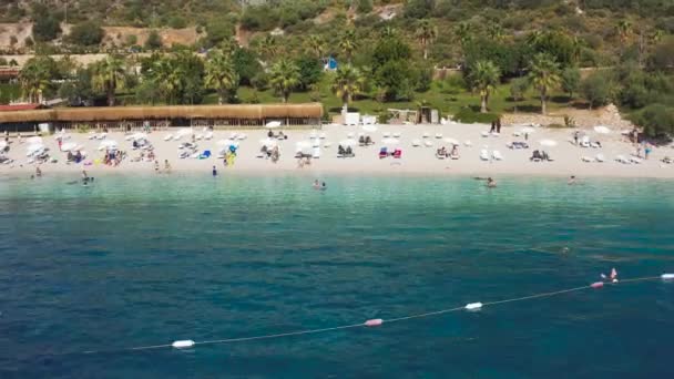 Vit sand Hidayet strand och turkost hav omgiven av berg i turist Kas stad, Turkiet. Flygvy 4K — Stockvideo