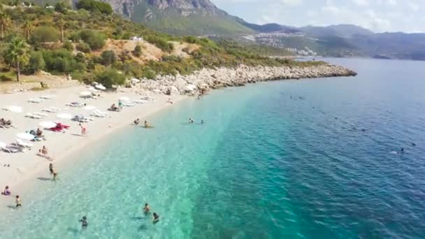 Aerial view azure sea and swiming people on the white sand beach on high mountains background in Kas, Antalya, Turkey. Aerial view 4K. — Vídeos de Stock