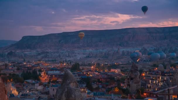 土耳其卡帕多西亚戈雷梅，一个色彩斑斓的热气球在夜间从岩石上起飞。时间过去4K. — 图库视频影像