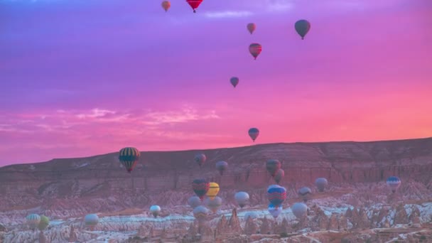 Landschaft aus bunten Luftballons in rosa Sonnenaufgang in Goreme, Kappadokien, Türkei. Zeitraffer 4K. — Stockvideo